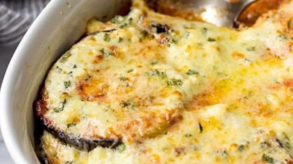 A closeup of eggplant with melted cheese over the top.