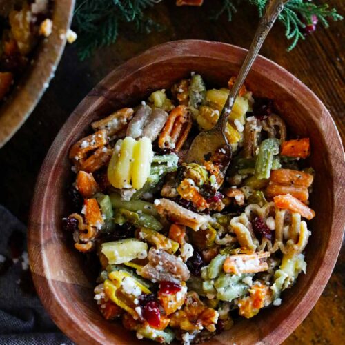 An overhead view of a wooden bowl filled with Fall Harvest Pasta Salad.