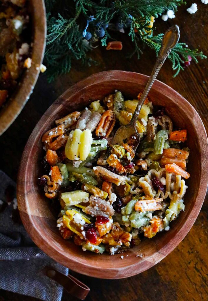 An overhead view of a wooden bowl filled with Fall Harvest Pasta Salad.