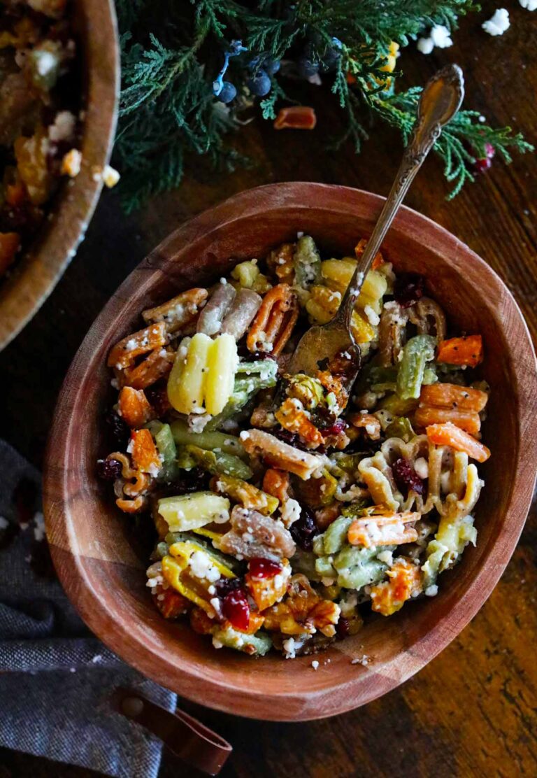 An overhead view of a wooden bowl filled with Fall Harvest Pasta Salad.