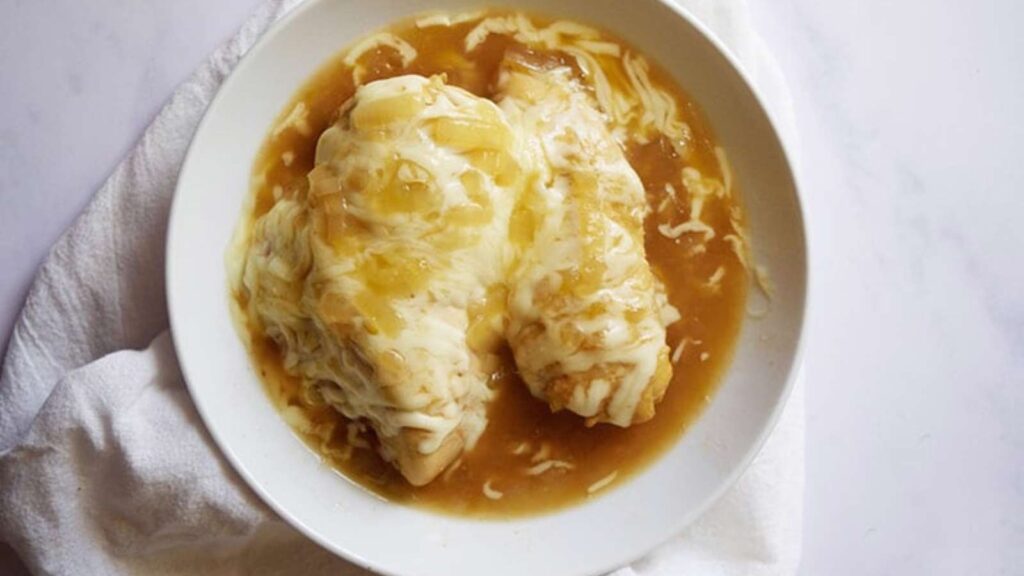 An overhead view of french onion chicken in a white bowl.