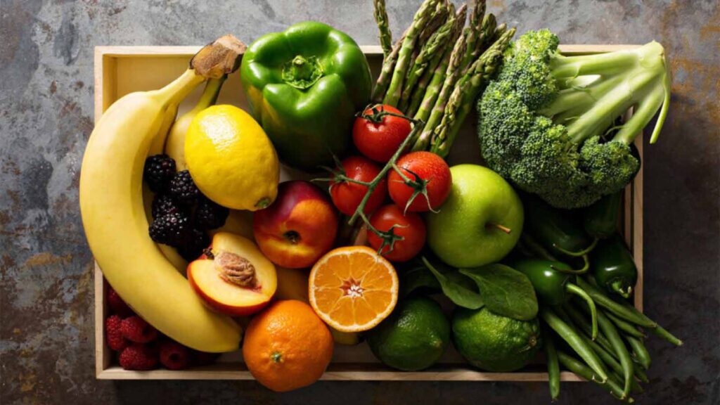 Fresh fruits and vegetable on a wooden tray.