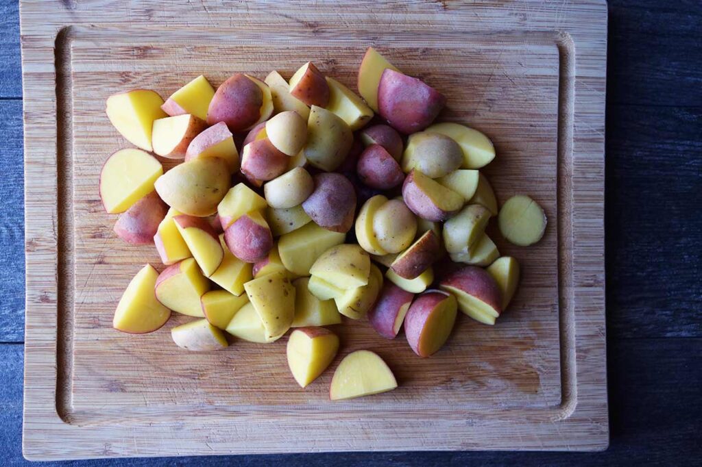 Cut potatoes on a cutting board.