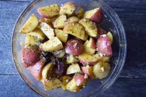 All the ingredients for this Garlic Lemon Potatoes Recipe mixed together in a mixing bowl.