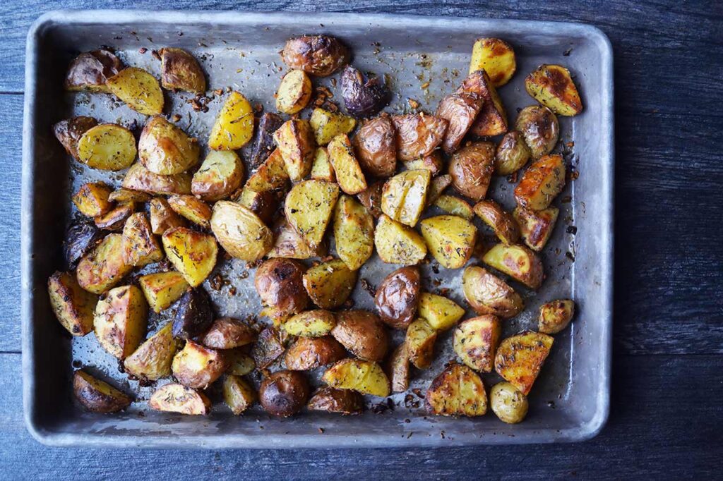 Roasted potatoes cooling on a baking sheet.