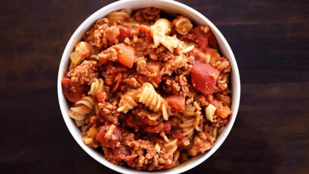 An overhead view of a white bowl filled with goulash.