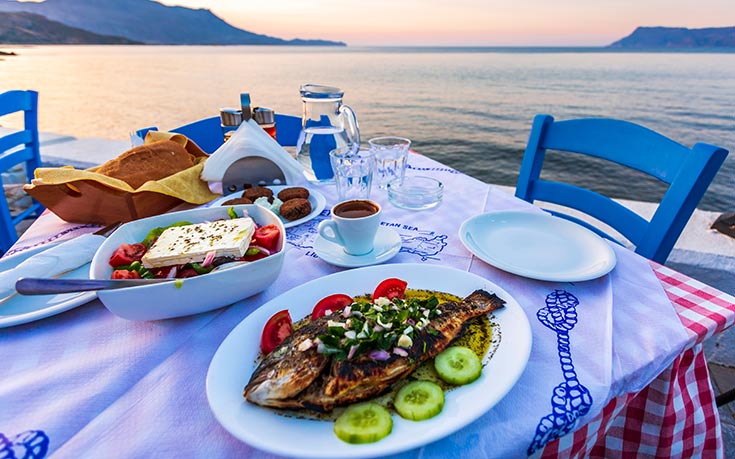 A dinner table set with food in the Greek Islands.
