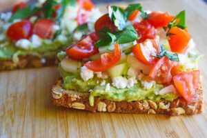 A side view of Greek Avocado Toast on a cutting board.