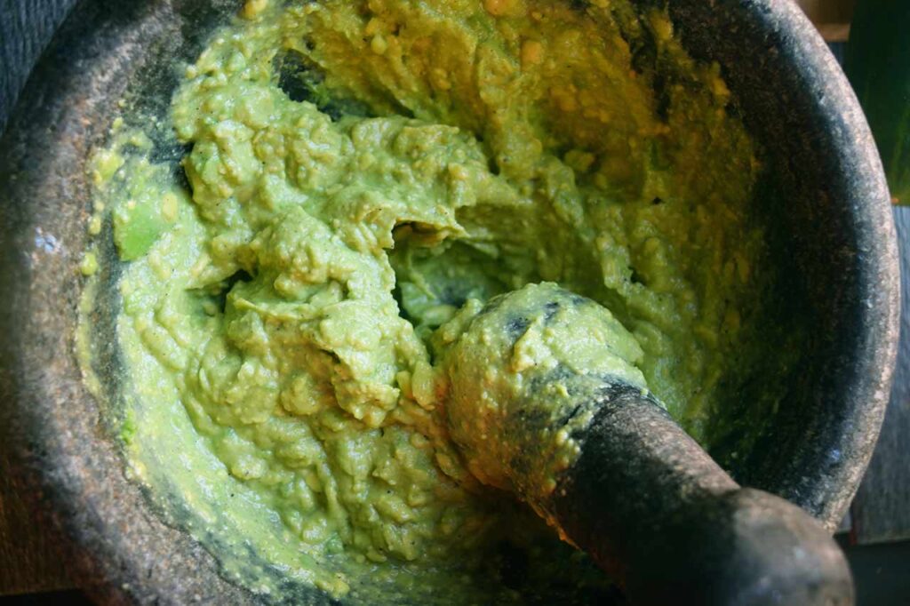 Avocado mashed with a mortar and pestle.