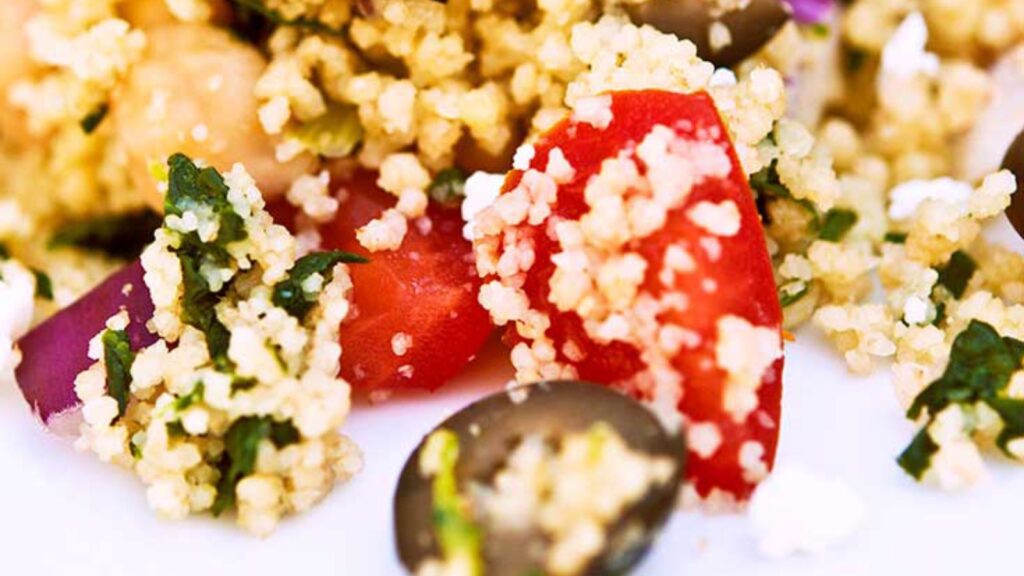 A closeup of Greek couscous on a white plate.