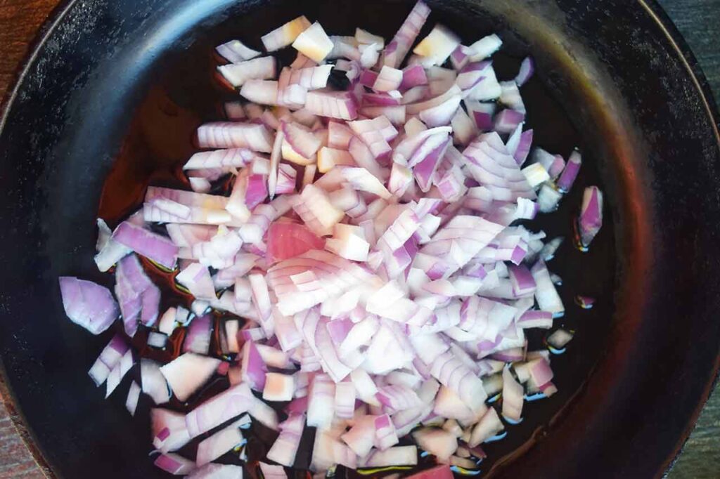 Raw chopped onions in a cast iron skillet.