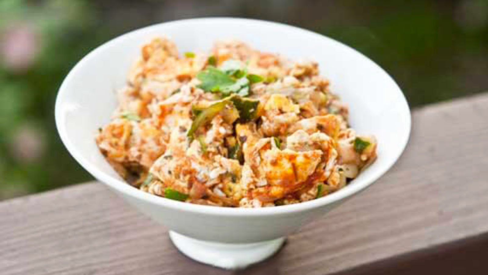 A white dish sitting on a ledge, filled with Italian Breakfast Scramble.