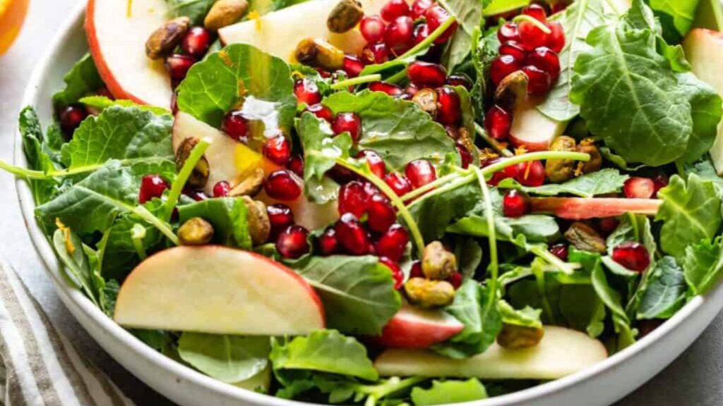 A kale and apple salad in a white bowl.