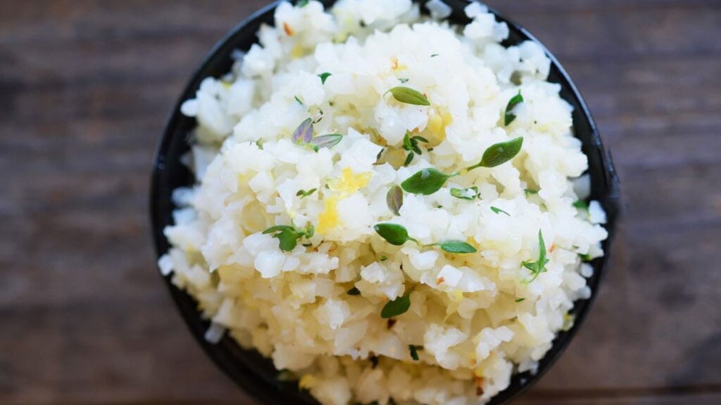 A black bowl filled with lemon thyme cauliflower rice.