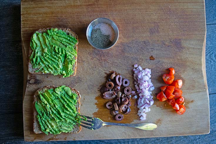 Smashed avocado on two slices of toasted bread.