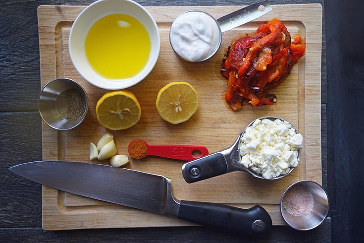 Mediterranean Roasted Red Pepper Dip Recipe ingredients laid out on a cutting board.