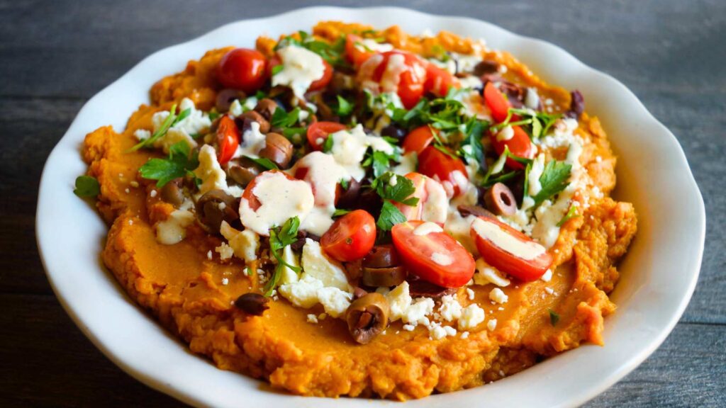 A finished Mediterranean Sweet Potato Casserole in a white, fluted, round dish.