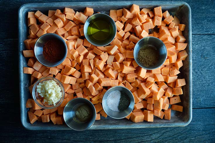 Mediterranean-Style Sweet Potato Casserole recipe ingredients collected on a sheet pan.