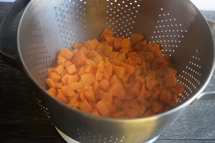 Sweet potato cubes drained in a colander.