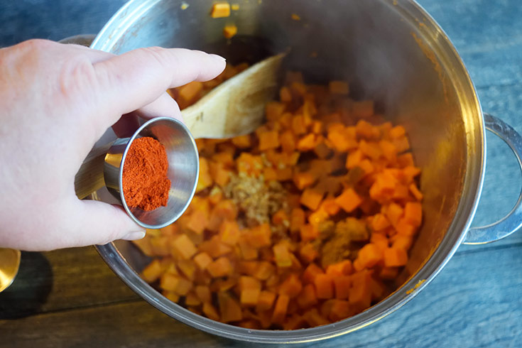 Adding spices to the sweet potatoes.