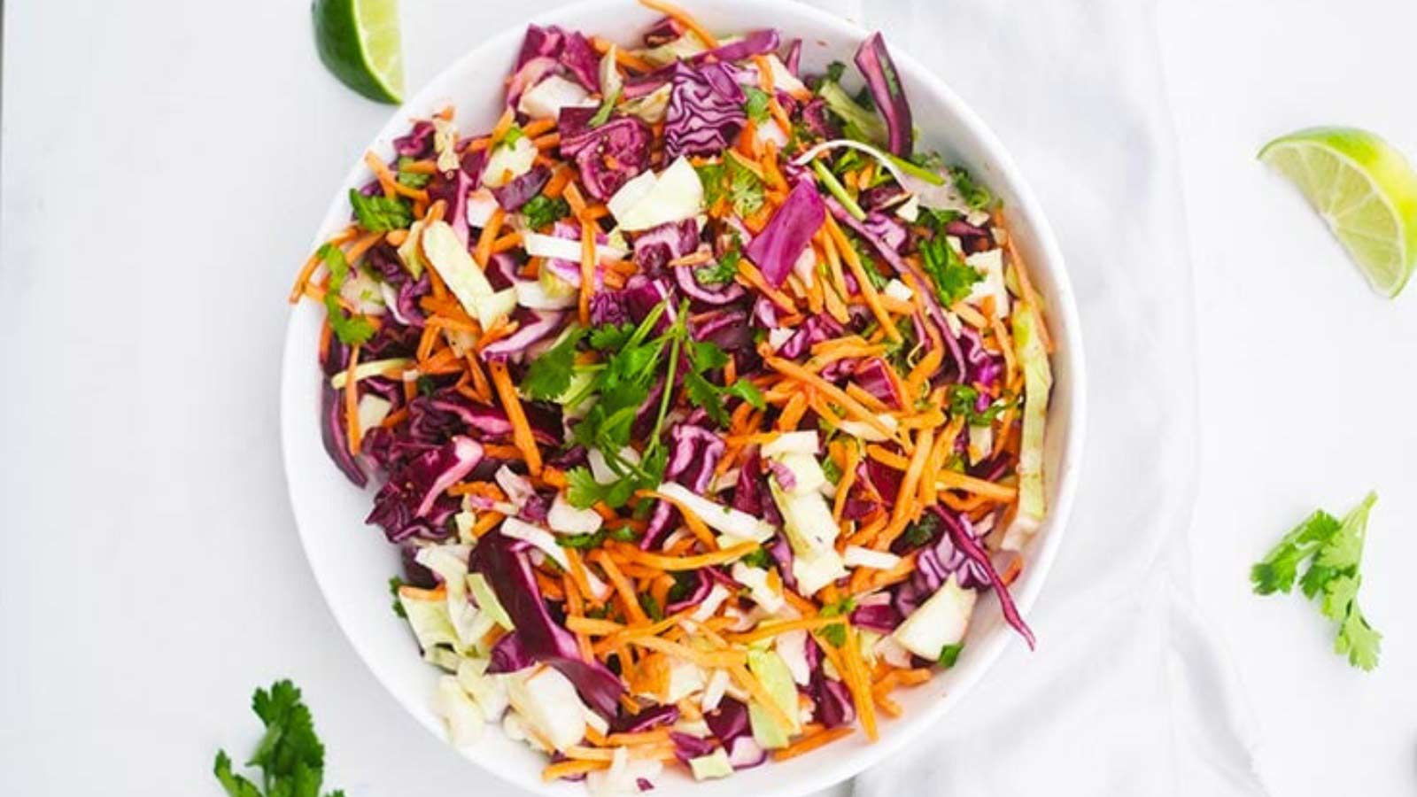 An overhead view of a white bowl filled with Mexican Coleslaw.