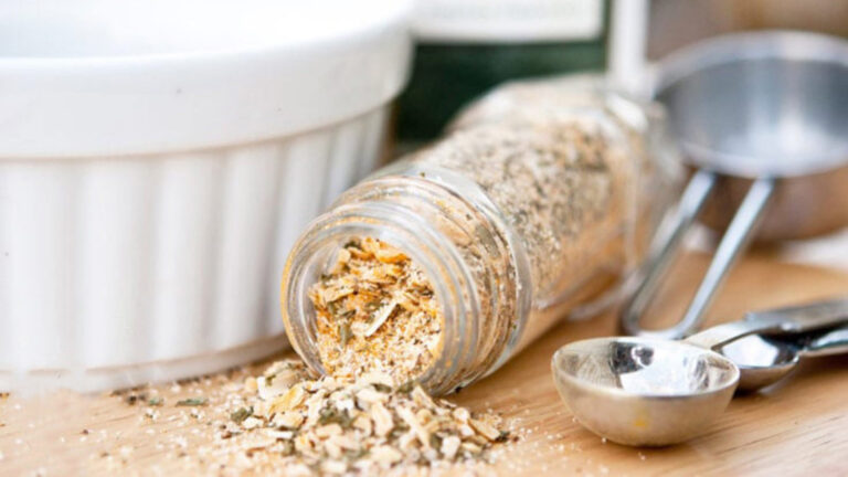 A jar of Onion Soup Mix tipped over on a cutting board.