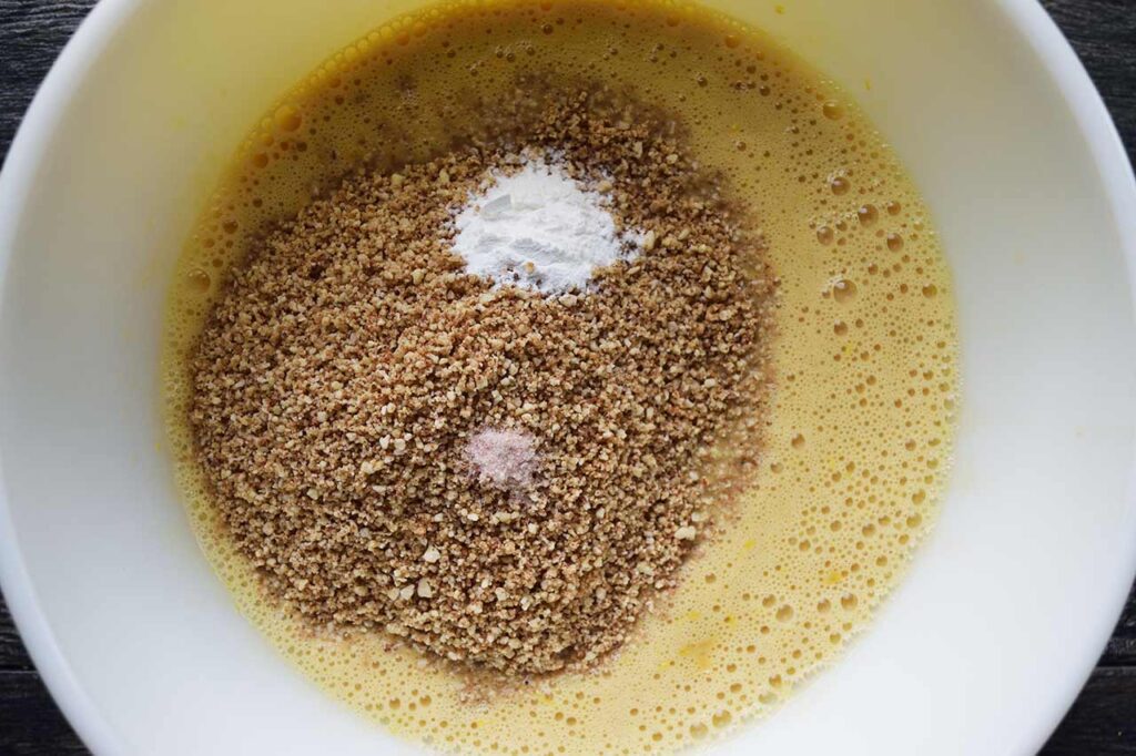 Dry ingredients added to the wet ingredients in a mixing bowl.