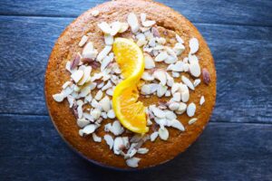 Sliced almonds and an orange twist added as garnish to the top of the cake.