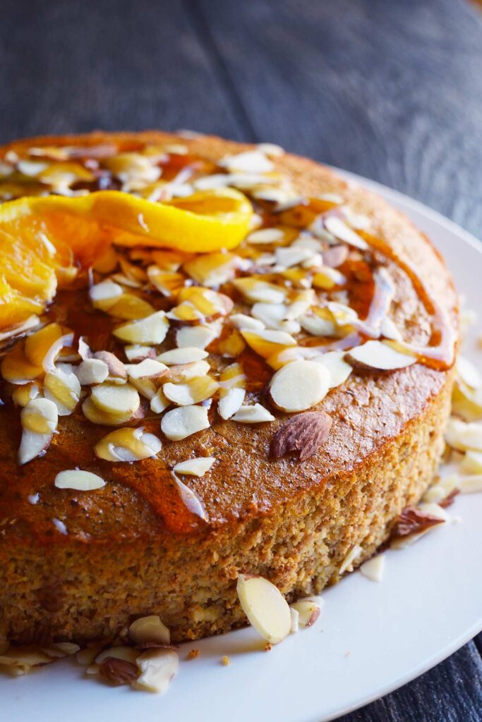 A side view of the finished Orange Almond Cake on a white platter.
