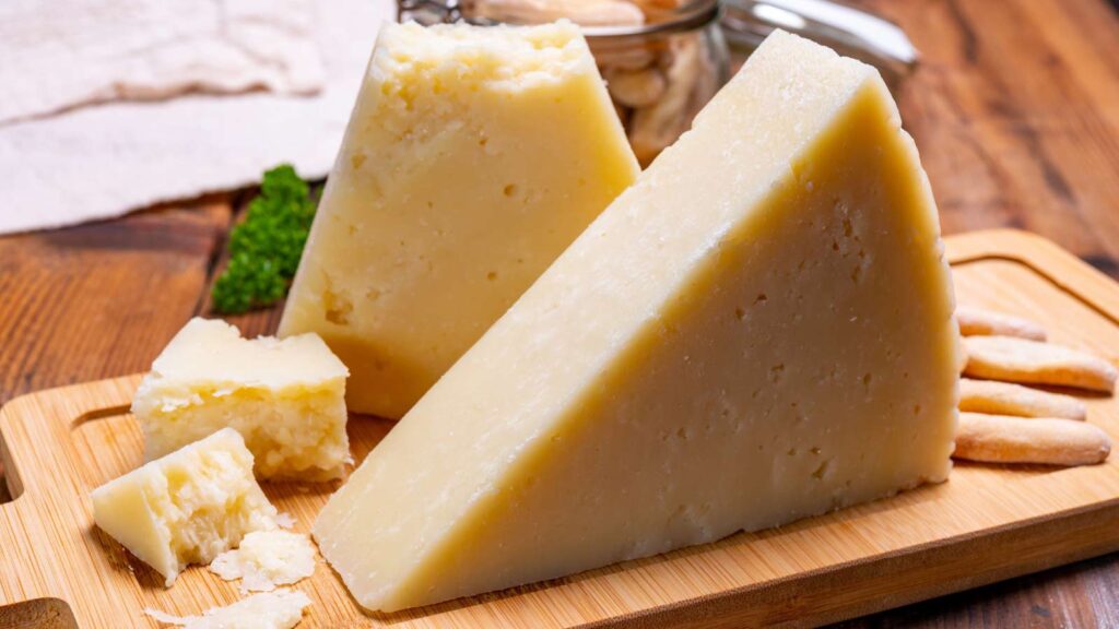 Two triangle blocks of pecorino cheese on a cutting board.