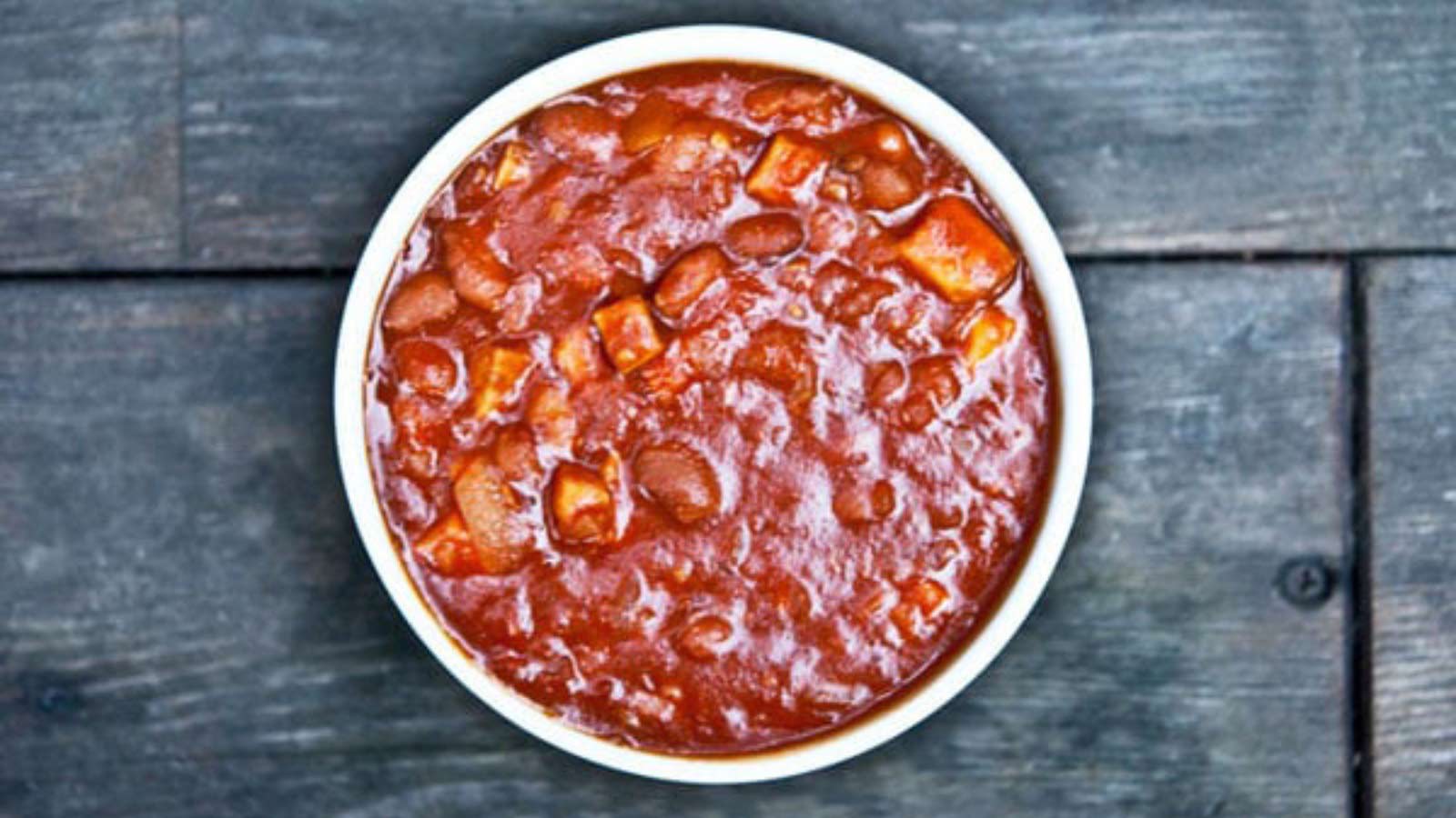 A white bowl filled with pork and beans.
