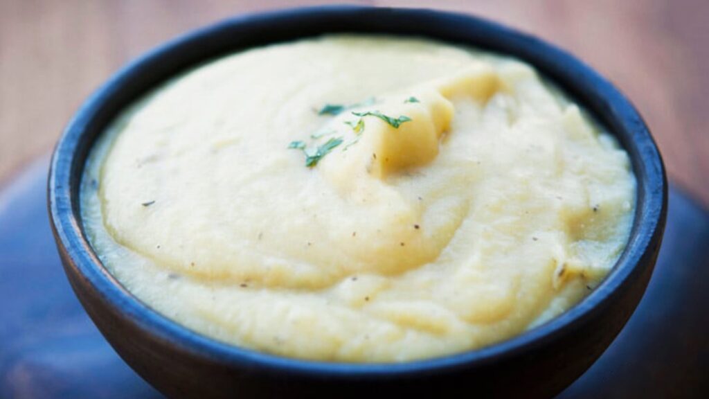 A black bowl filled with potato leek soup.