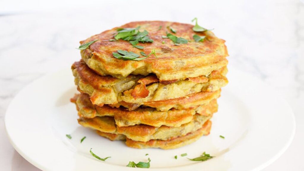 A stack of potato pancakes on a white plate.