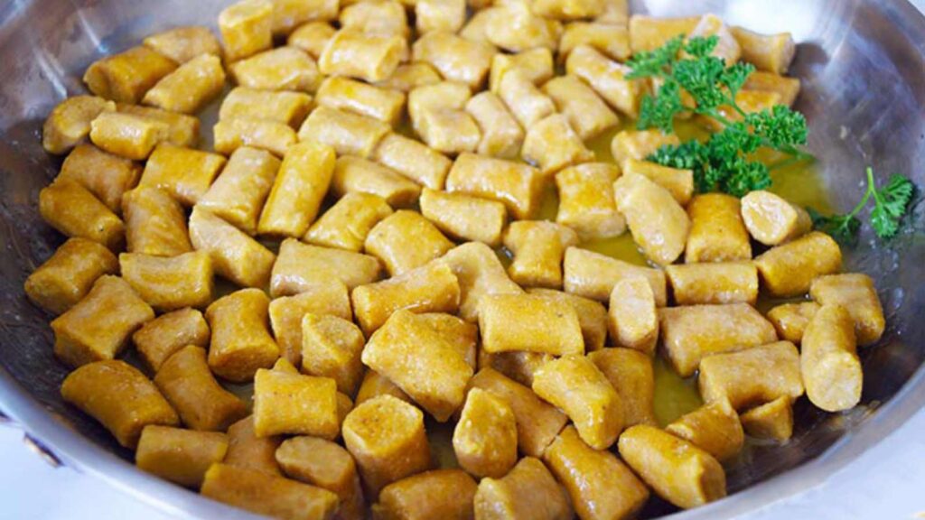 A pan full of Pumpkin Gnocchi with a bit of fresh parsley on the side.