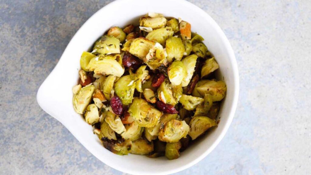 A white bowl filled with Roasted Garlic Brussels Sprouts Salad.