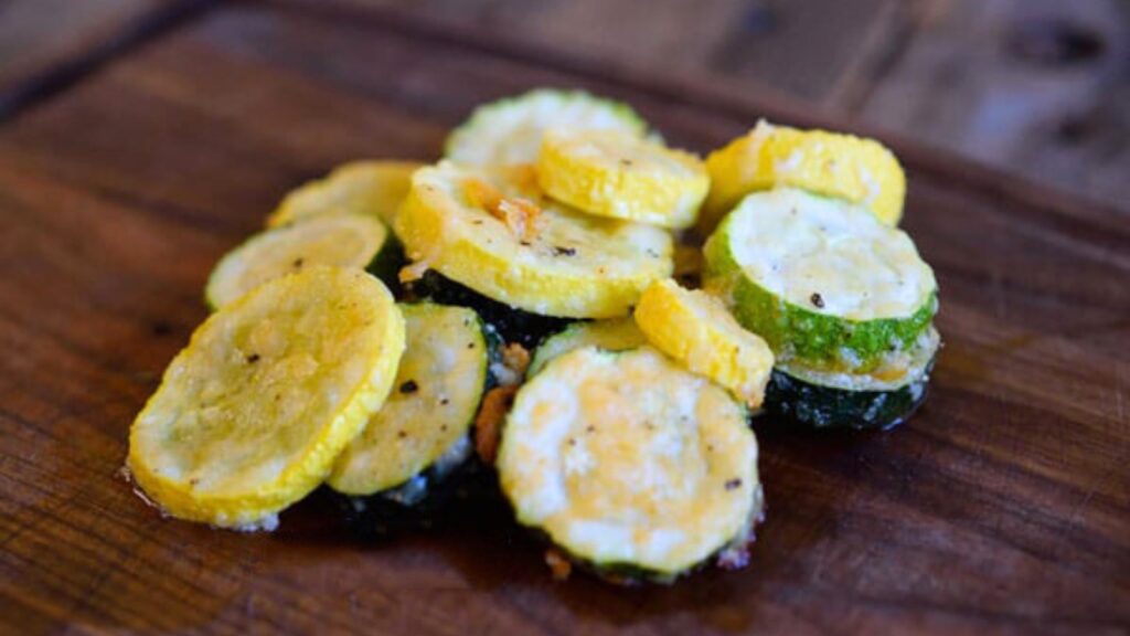 A pile of roasted summer squash on a cutting board.