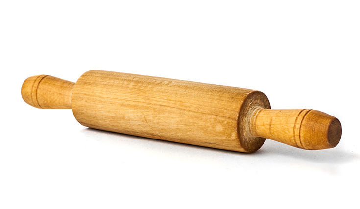 A wooden rolling pin on a white surface.