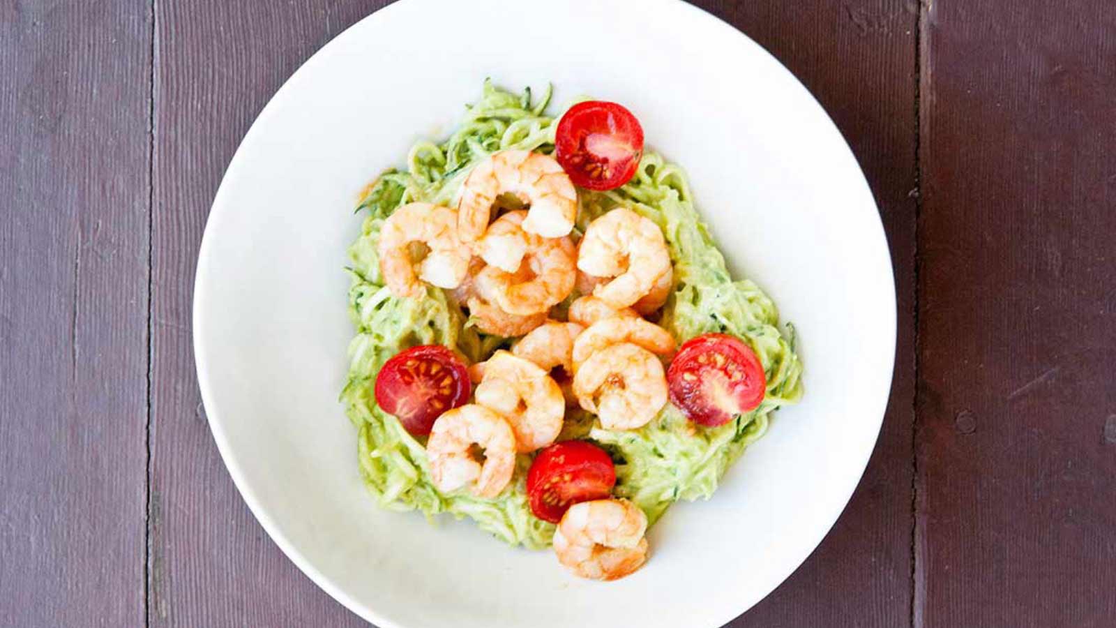 Shrimp Zucchini Pasta With Avocado Pesto Alfredo in a white bowl.