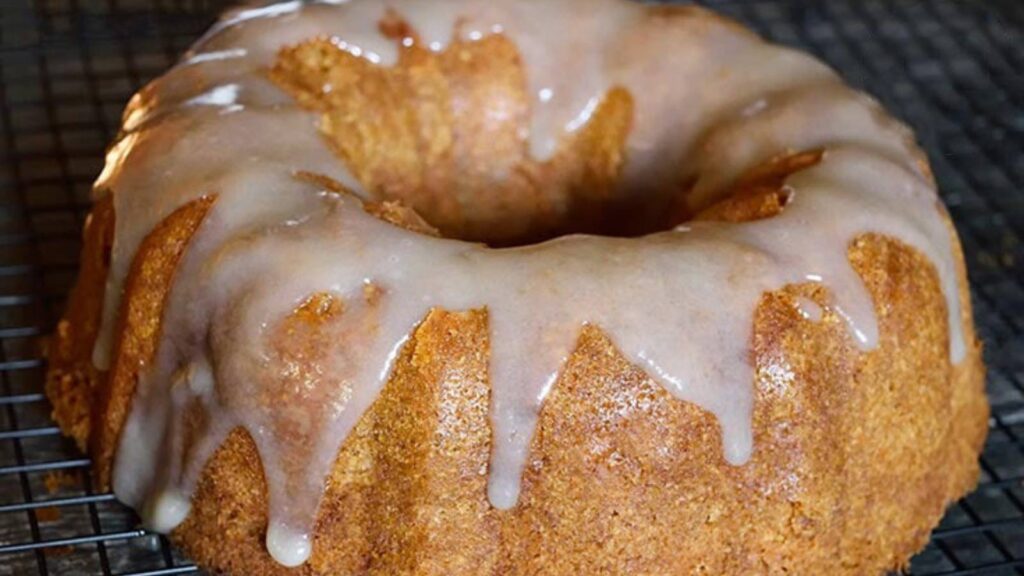 A Spiced Apple Bundt Cake with glaze sitting on a wire cooling rack.