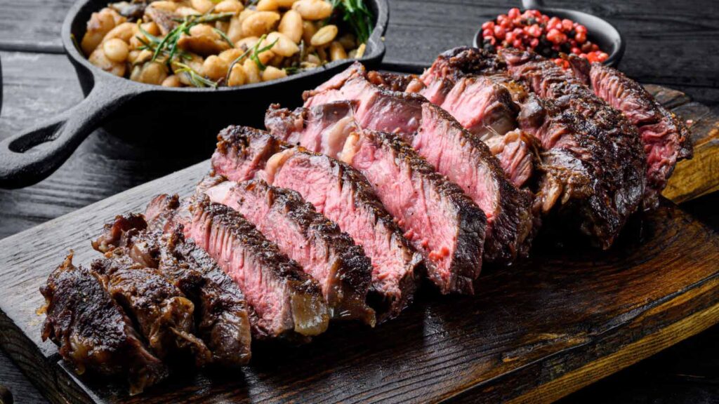 A sliced steak on a cutting board.