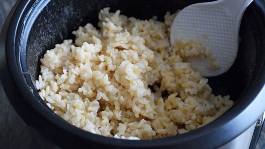 A crock full of sticky brown rice that's just been cooked.