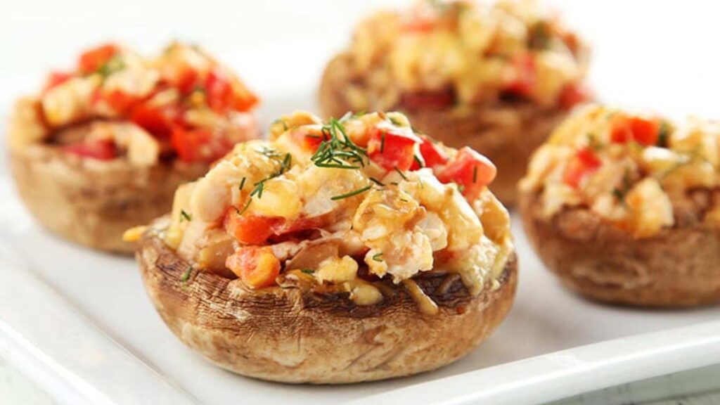 A white platter of stuffed mushrooms.