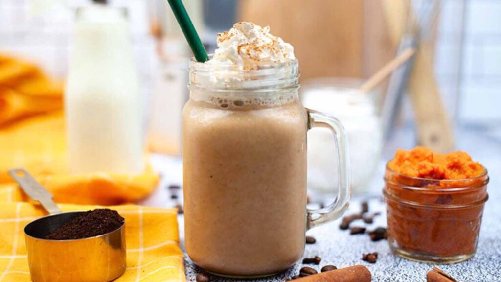 The finished Sugar Free Pumpkin Spice Coffee Creamer mixed into a latte, topped with whipped cream and cinnamon in a glass mug.