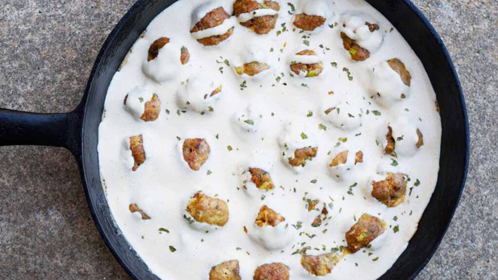 An overhead view of a cast iron skillet filled with dairy-free Swedish meatballs.