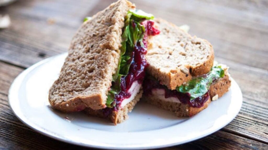 A Thanksgiving Traditional Leftover Sandwich on a white plate.