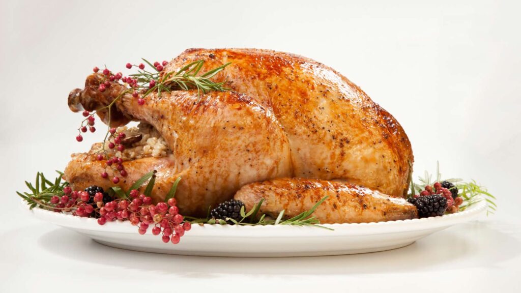 A thanksgiving turkey on a white platter on a white background.