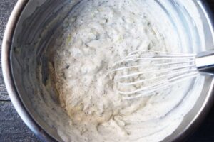 Mixed Tzatziki in a silver mixing bowl.