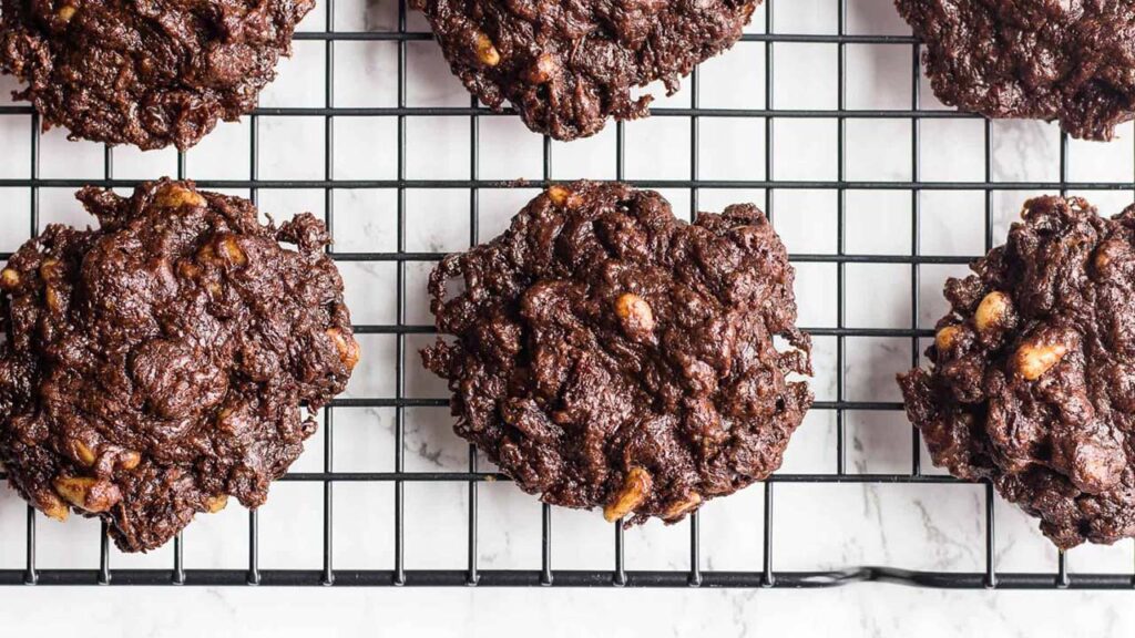 Vegan chocolate brownie cookies cooling on a wire rack.