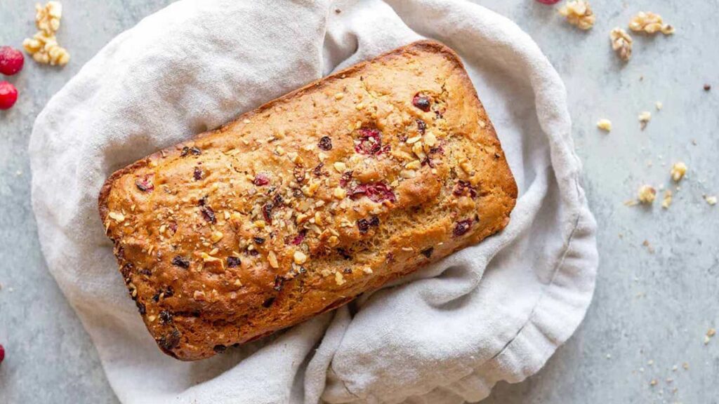 An overhead view of a loaf of vegan cranberry orange bread.