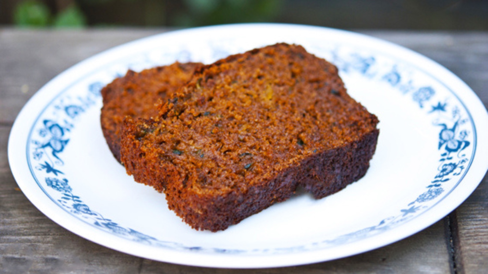Two slices of zucchini bread lay on a plate.